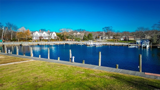 view of dock with a water view and a yard