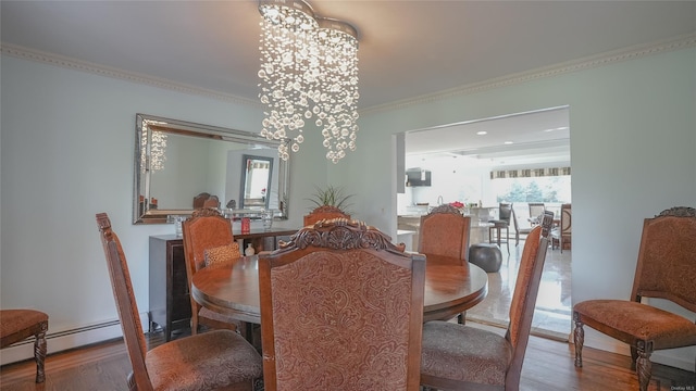 dining space with hardwood / wood-style flooring, an inviting chandelier, baseboard heating, and crown molding