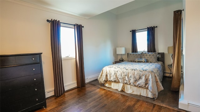 bedroom featuring baseboard heating, multiple windows, and dark wood-type flooring