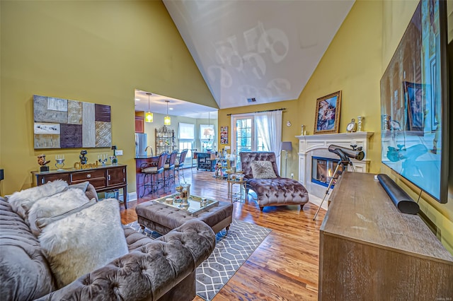 living room featuring hardwood / wood-style flooring and high vaulted ceiling