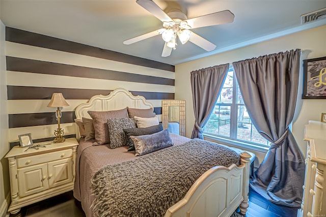 bedroom with dark hardwood / wood-style flooring and ceiling fan