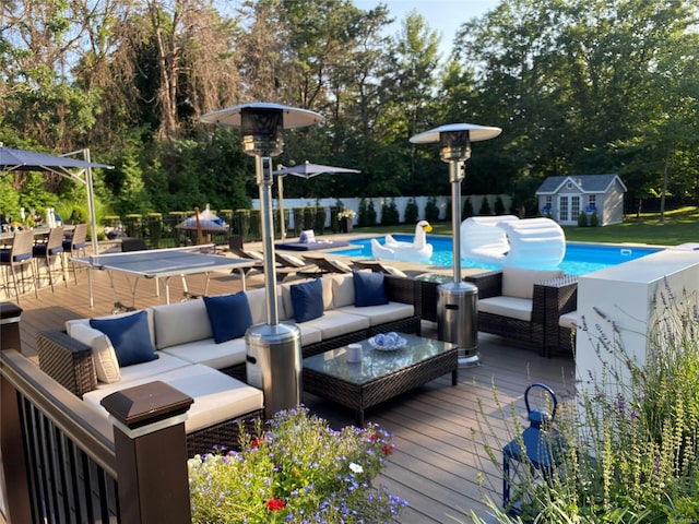 view of swimming pool with an outdoor living space and a wooden deck