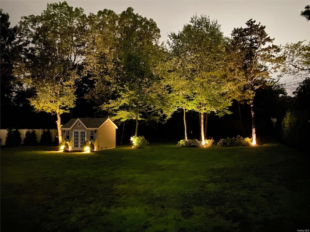 yard at dusk featuring an outbuilding