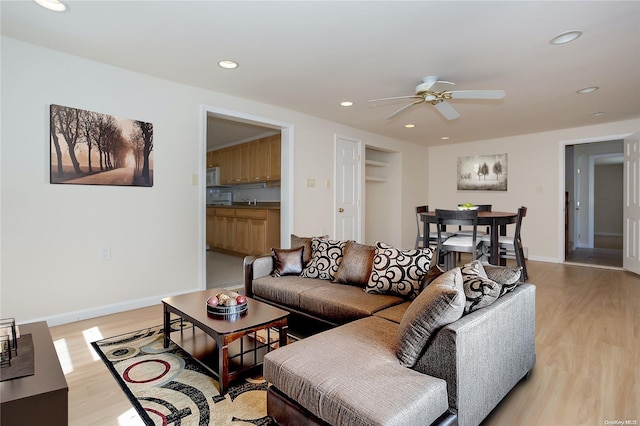 living room featuring ceiling fan and light hardwood / wood-style floors