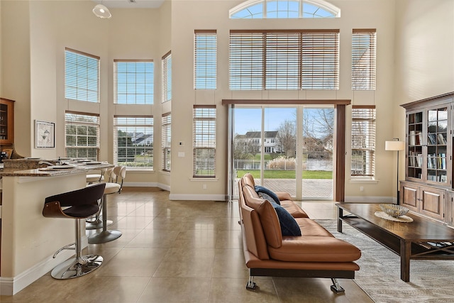 living room featuring light tile patterned flooring and a high ceiling