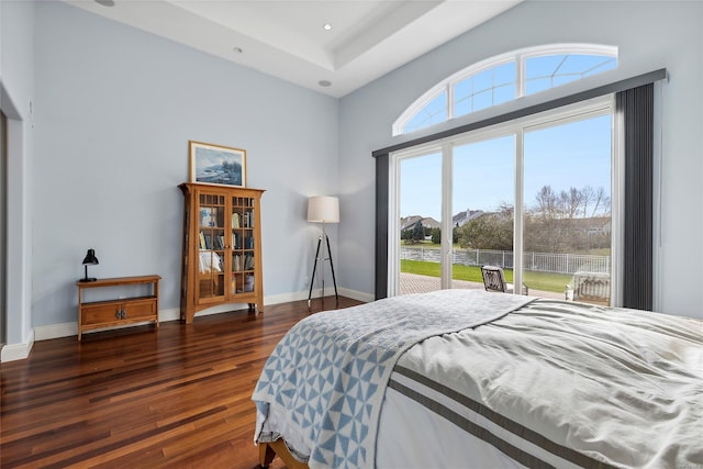 bedroom featuring dark hardwood / wood-style flooring and a high ceiling