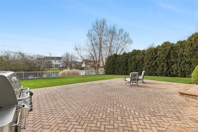 view of patio with a water view and a grill