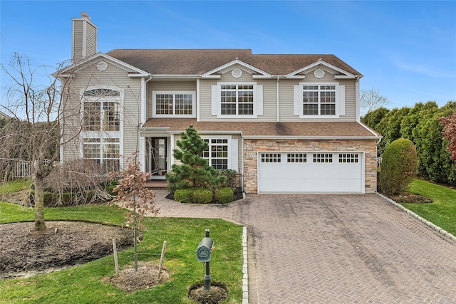 view of front of house featuring a garage and a front lawn