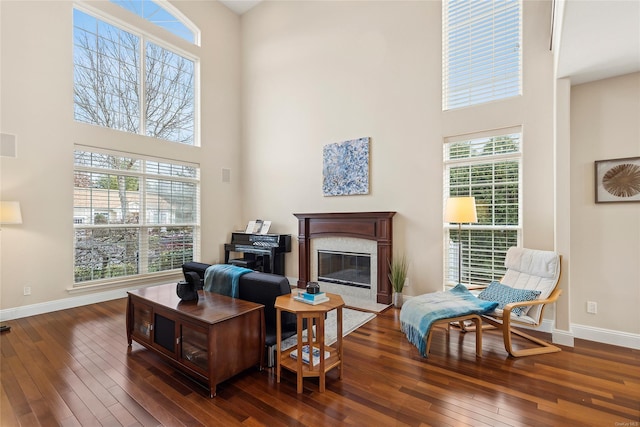 living room with a towering ceiling and dark wood-type flooring