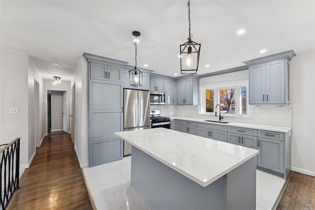 kitchen with light stone countertops, appliances with stainless steel finishes, gray cabinetry, sink, and hanging light fixtures