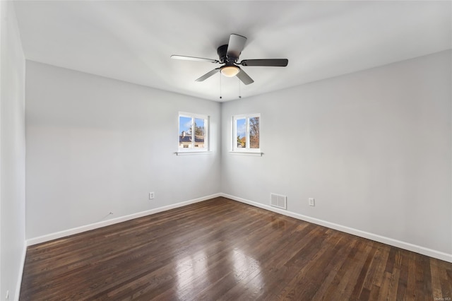 empty room with dark hardwood / wood-style flooring and ceiling fan