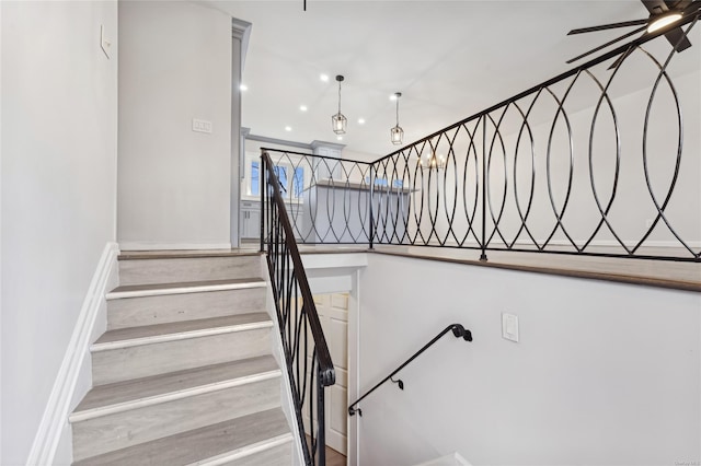 stairway with ceiling fan and hardwood / wood-style floors