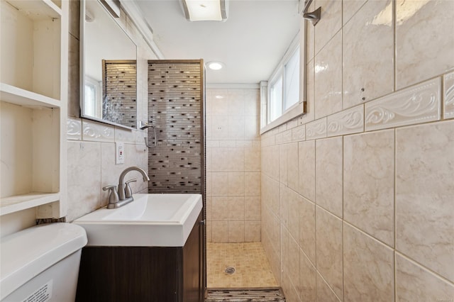 bathroom with a tile shower, toilet, decorative backsplash, vanity, and tile walls