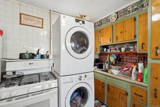 washroom with stacked washing maching and dryer and sink