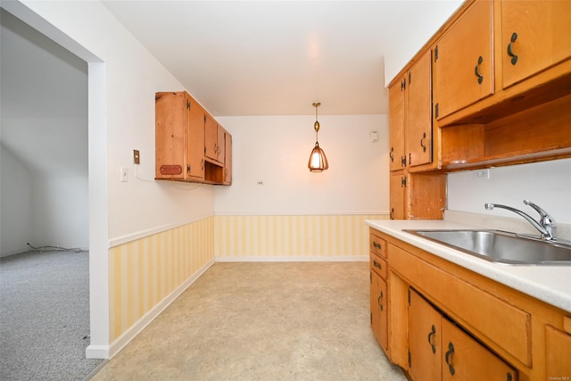 kitchen featuring sink, light colored carpet, and pendant lighting