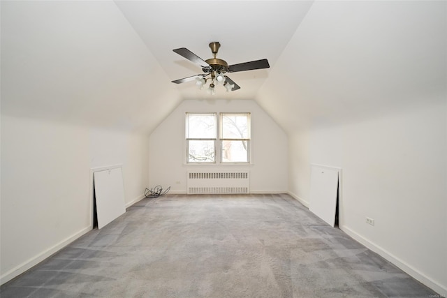 additional living space featuring ceiling fan, radiator heating unit, light colored carpet, and lofted ceiling