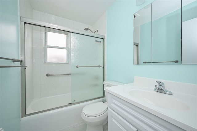 full bathroom with vanity, bath / shower combo with glass door, and toilet