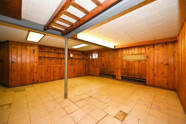 basement with baseboard heating and wooden walls