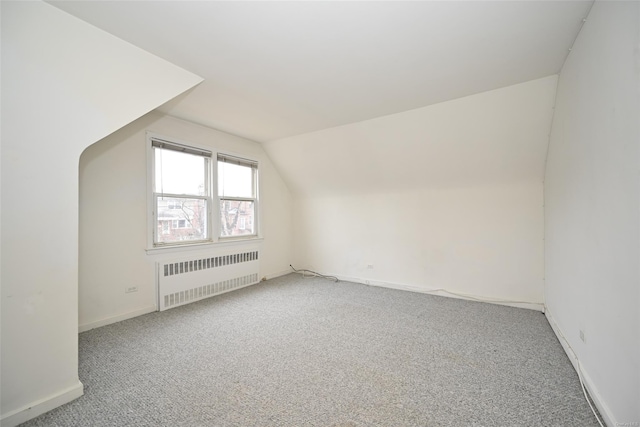 bonus room with radiator, carpet floors, and vaulted ceiling