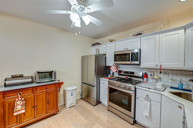 811 Spring Lake Dr Unit 811, Middle Island, NY 11953 - kitchen with appliances with stainless steel finishes, light wood-style floors, decorative backsplash, ceiling fan, and light stone counters