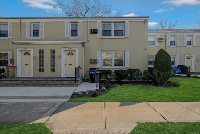 townhome / multi-family property featuring a front lawn