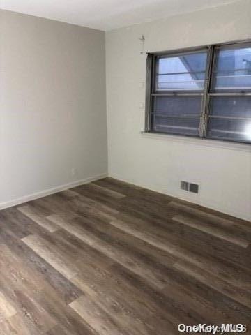 unfurnished room featuring dark wood-type flooring