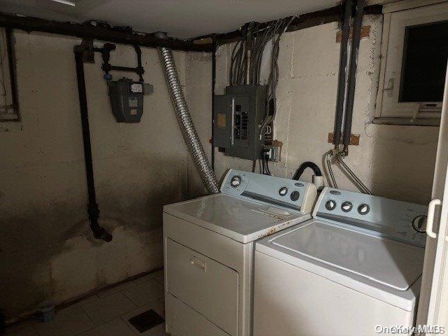 laundry area with electric panel and washing machine and dryer