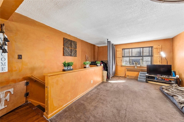 living room featuring dark colored carpet, radiator heating unit, and a textured ceiling