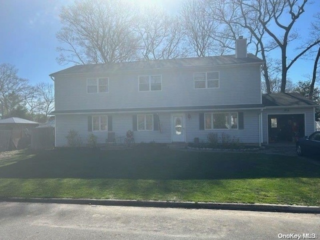 view of front of house with a garage and a front lawn