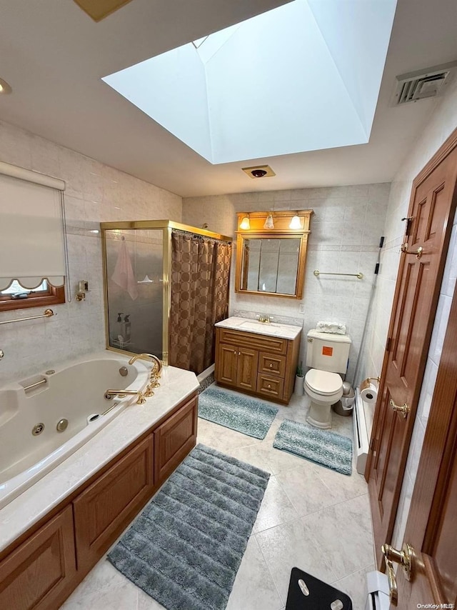 full bathroom featuring toilet, tile walls, a skylight, independent shower and bath, and vanity