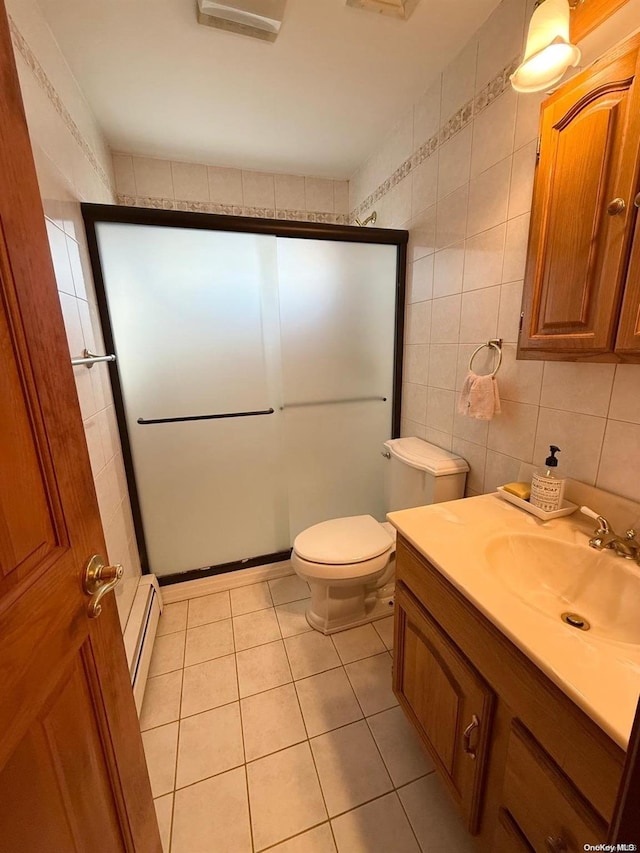 bathroom featuring tile patterned flooring, tile walls, walk in shower, vanity, and baseboard heating