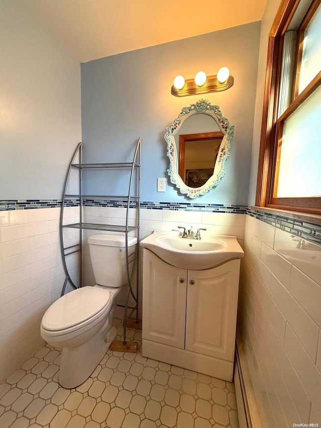 bathroom featuring tile walls, vanity, and toilet