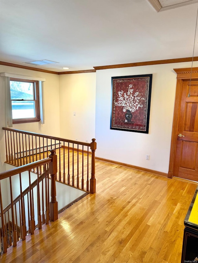 hall featuring hardwood / wood-style floors, crown molding, and a baseboard heating unit