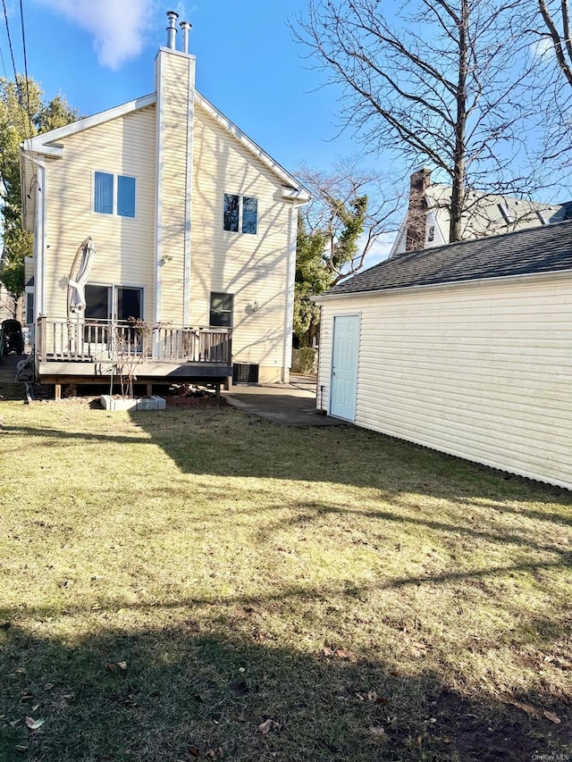 back of house featuring a yard and a deck