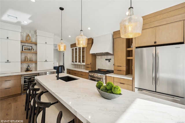 kitchen with white cabinetry, sink, stainless steel appliances, tasteful backsplash, and custom range hood