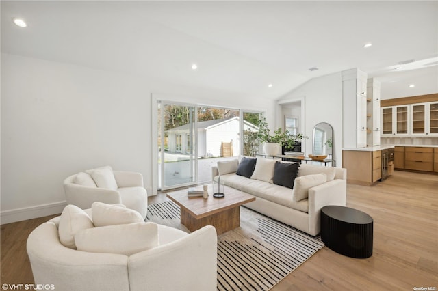 living room with light hardwood / wood-style floors and vaulted ceiling