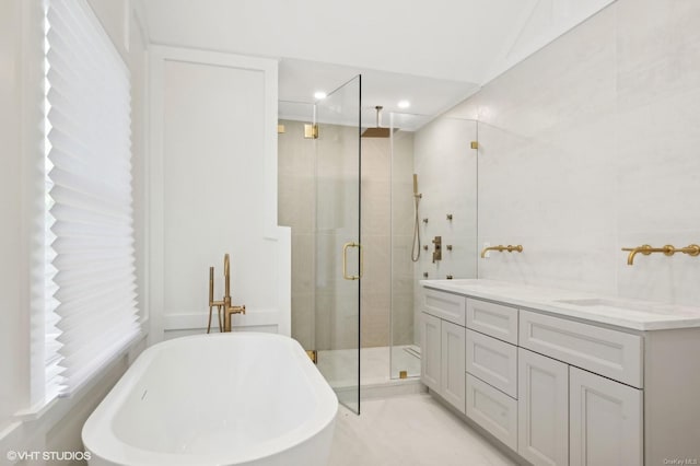 bathroom with vanity, tile walls, and shower with separate bathtub