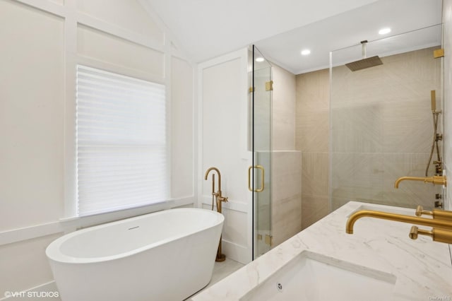 bathroom featuring vanity, separate shower and tub, and lofted ceiling