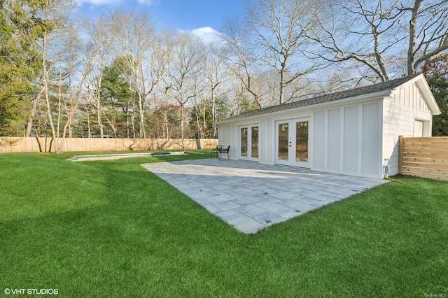 back of property with a lawn, a patio area, and french doors