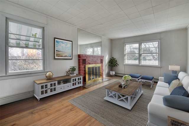 living room with wood-type flooring, a fireplace, and a baseboard radiator