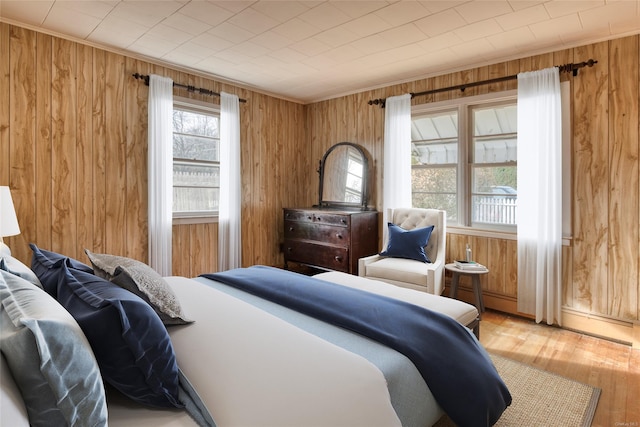 bedroom featuring light hardwood / wood-style floors and wooden walls