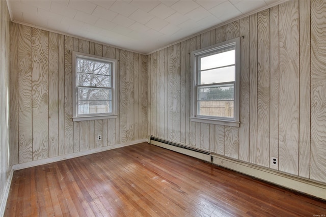 unfurnished room with hardwood / wood-style flooring and a baseboard radiator