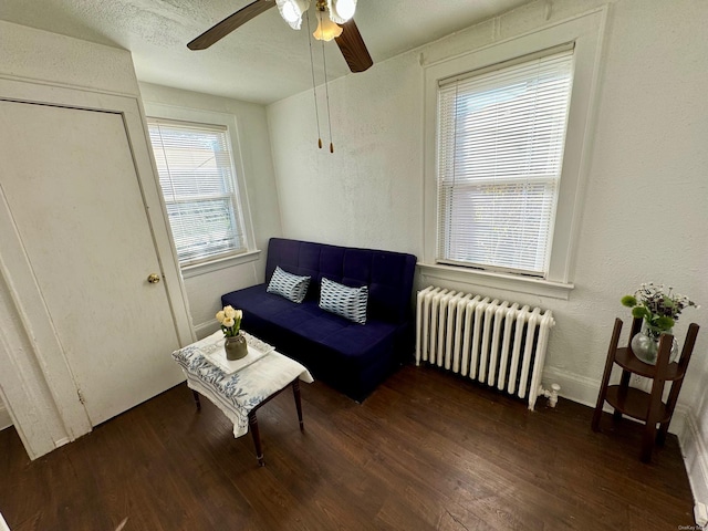 sitting room with ceiling fan, dark hardwood / wood-style flooring, a textured ceiling, and radiator