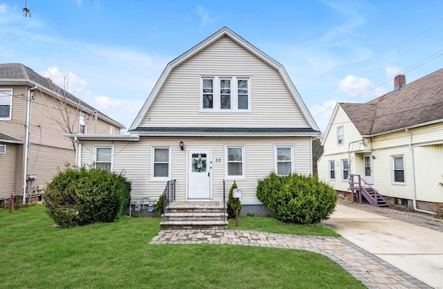 back of house with a gambrel roof and a yard