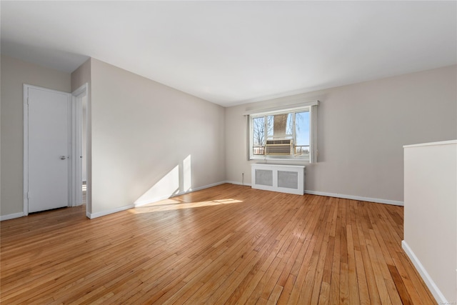 unfurnished living room with radiator heating unit and light hardwood / wood-style flooring