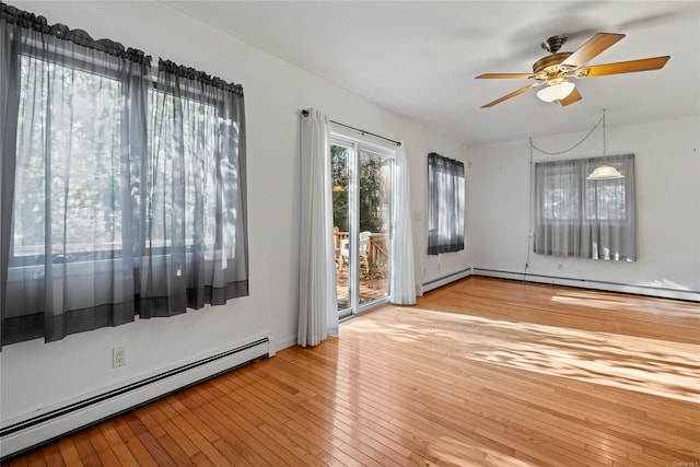 unfurnished room with light wood-type flooring, baseboard heating, and ceiling fan