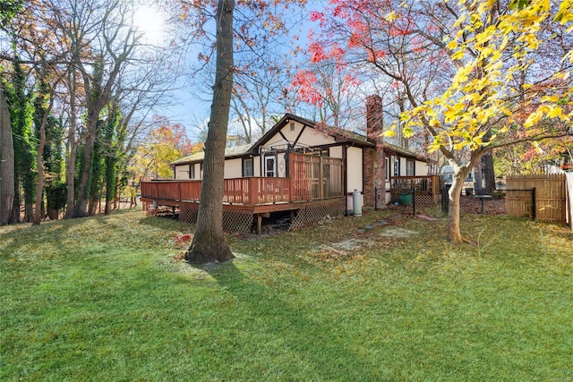 rear view of house with a yard and a deck