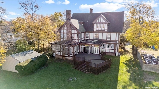 back of house featuring a lawn and a wooden deck