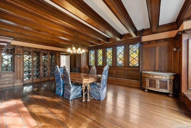 unfurnished dining area with wood walls, a notable chandelier, beam ceiling, and wood-type flooring