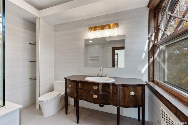 bathroom with vanity, toilet, and tile walls